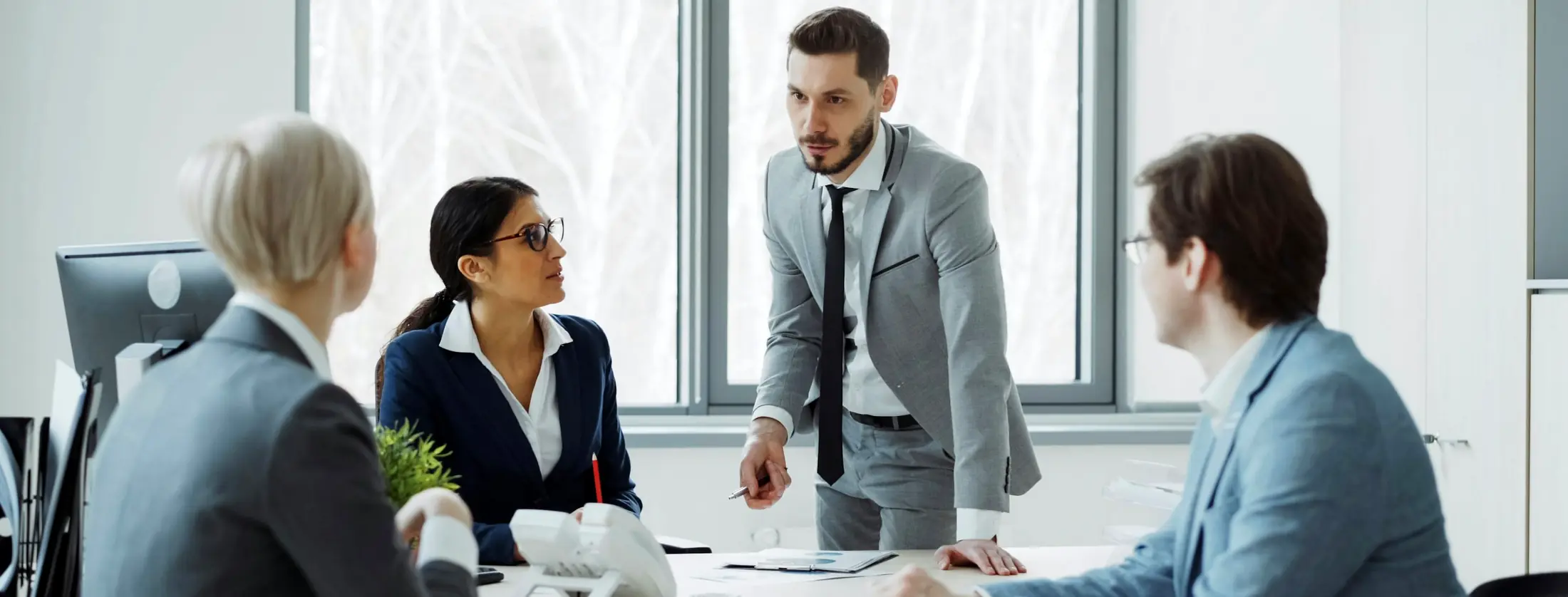 A leadership team in discussion around a boardroom table